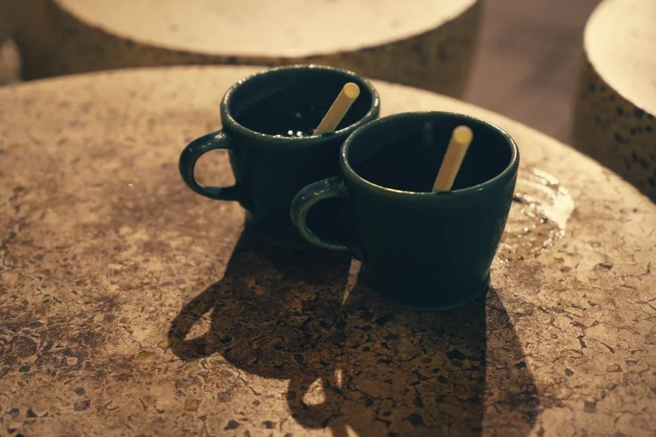 Deux tasses posées côte à côte sur une table : le bouche-à-oreille, une recommandation qui passe d'une personne à une autre.