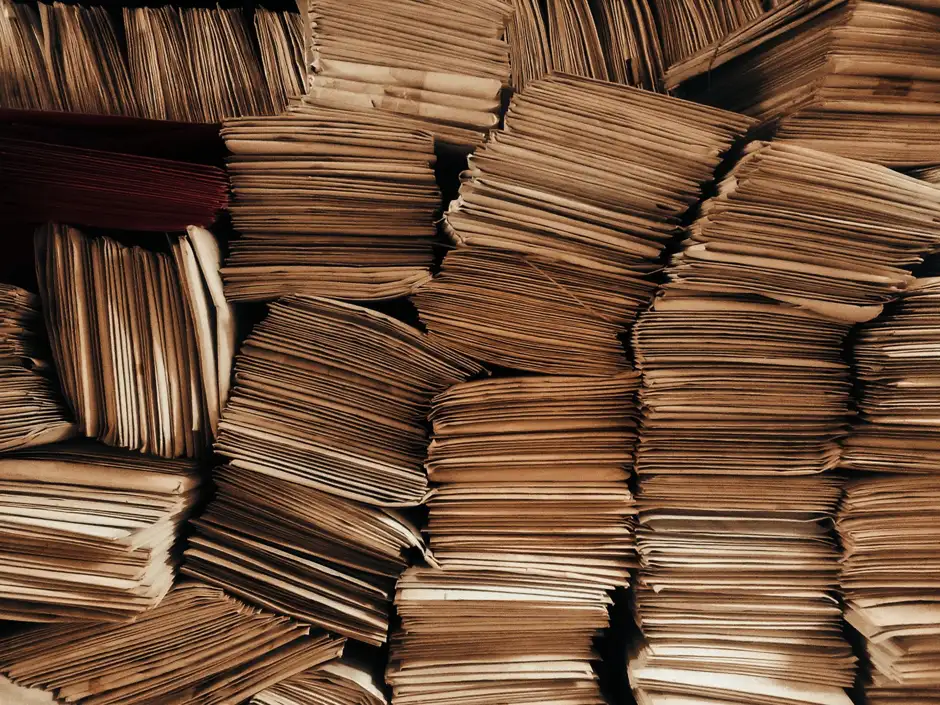 Piles d'enveloppes en papier kraft empilées et alignées, toutes identiques — symbole du courrier envoyé en masse malgré une apparence individuelle.